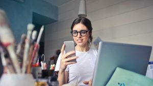 woman in white shirt using smartphone