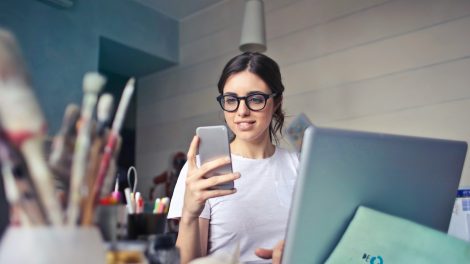 woman in white shirt using smartphone