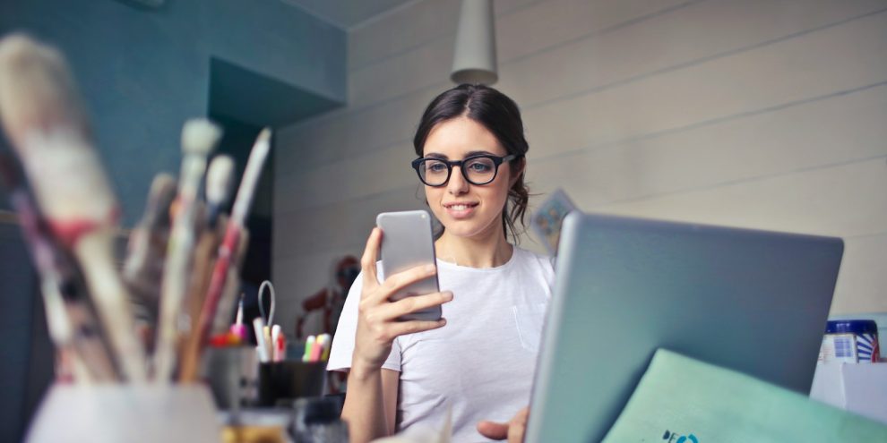woman in white shirt using smartphone