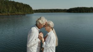 Senior couple in love sharing a tender moment by a tranquil lakeside.